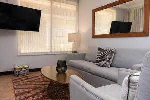 a living room with a couch and a tv at Corteza 2BD Gated AC Quiet Terrace Pools in Jacó