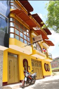 ein Motorrad, das vor einem gelben Gebäude parkt in der Unterkunft krusty Backpackers Hostel B&B in Huaraz