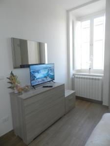 a bedroom with a dresser with a television on it at JeD SWEET DREAMS in LʼAquila