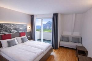 a bedroom with a large white bed and a window at Hotel Comfort Erica Dolomiti Val d'Adige in Salorno