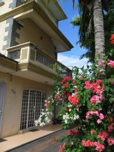 ein Gebäude mit rosa Blumen und einem Balkon in der Unterkunft Residence Dream Lodge in Flic-en-Flac