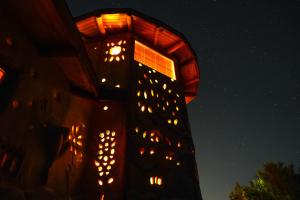 a building with lights on the side of it at night at Swiss Eco Lodge La Linda Loma - Olmué in Olmué