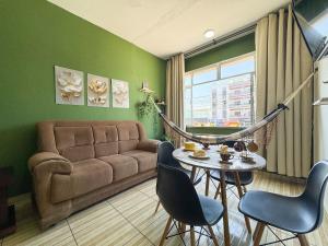 a living room with a couch and a table and chairs at Apto na beira da praia do Centro | ROMM109 in Rio das Ostras