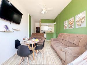 a living room with a couch and a table at Apto na beira da praia do Centro | ROMM109 in Rio das Ostras