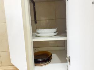 a cabinet with a bowl and plates on a shelf at Apto na beira da praia do Centro | ROMM109 in Rio das Ostras +19 photos