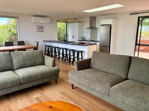 a living room with two couches and a kitchen at 45 degrees South in Kakanui