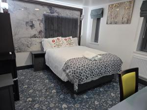 a bedroom with a bed with a black and white comforter at Ababeel Hotel in Birmingham +36 photos