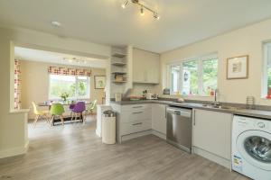a kitchen with a washing machine and a dining room at Hendre-Llangwm in Llangwm