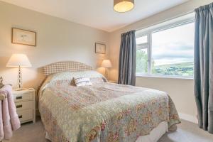 a bedroom with a bed and a window at Hendre-Llangwm in Llangwm