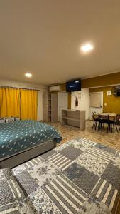 een slaapkamer met een bed en een tafel met een kamerscherm bij Cabaña Concepcion del Valle in Salsacate