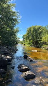 een rivier met rotsen en bomen aan de zijkant bij Cabaña Concepcion del Valle in Salsacate +10 foto's