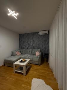 a living room with a couch and a table at Apartmani Sirius in Čačak