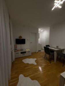 a living room with a table and chairs and a dining room at Apartmani Sirius in Čačak