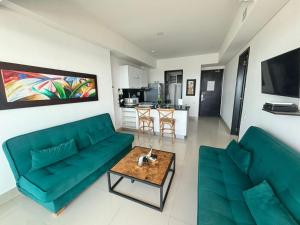 卡塔赫纳Playa Cartagena Apartments的客厅里有一张绿色的沙发和一张桌子
