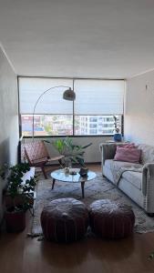 ein Wohnzimmer mit Sofa und Tisch in der Unterkunft Providencia, ubicación y vista extraordinaria, con AC in Santiago