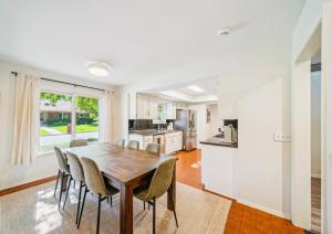 a kitchen and dining room with a wooden table and chairs at Heart of Tulsa, pool, game room, Sleeps 8 in Tulsa