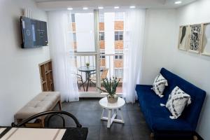 a living room with a blue couch and a table at Apartamento Moderno en Villeta - Nido de San Miguel in Villeta