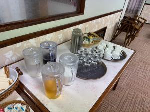 einen Tisch mit Gläsern und Teller mit Speisen und Getränken in der Unterkunft 高嶺荘 in Otari