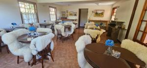 een woonkamer met witte stoelen, tafels en een wit tafelblad bij Pousada Flor de Lua Monte Verde in Monte Verde
