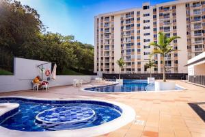a swimming pool in front of a tall building at Apartamento Moderno en Villeta - Nido de San Miguel in Villeta