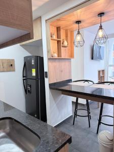 una cucina con frigorifero nero e tavolo di Apartamento Moderno en Villeta - Nido de San Miguel a Villeta