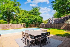 a patio with a table and chairs next to a pool at Heart of Tulsa, pool, game room, Sleeps 8 in Tulsa