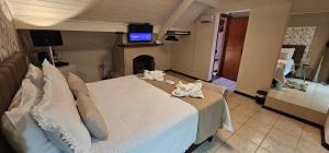 a bedroom with a large bed with towels on it at Pousada Flor de Lua Monte Verde in Monte Verde