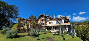 een huis met een speeltuin ervoor bij Pousada Flor de Lua Monte Verde in Monte Verde