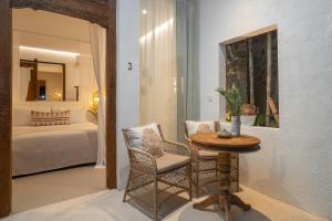 a room with a table and chairs and a bedroom at The Balangan Hotel Uluwatu - 2min to Beach & 5min to Bali's Best Golf in Uluwatu +45 photos