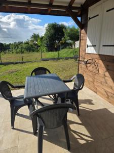 a picnic table and two chairs on a patio at Guayaba in Sainte-Anne