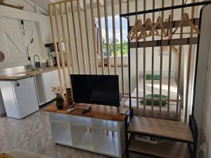 a kitchen with a desk with a television on it at Guayaba in Sainte-Anne +3 photos