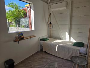 a bedroom with a bed and a window at Guayaba in Sainte-Anne