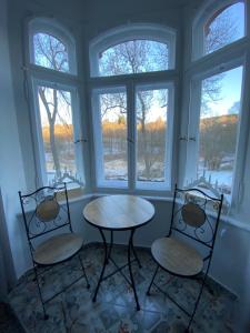 zwei Stühle und ein Tisch in einem Zimmer mit Fenstern in der Unterkunft frankys cafe in Bärenstein