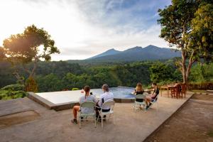 un groupe de personnes assises autour d'une table au bord d'un billard dans l'établissement Senaru Paradise, à Senaru 30 autres photos