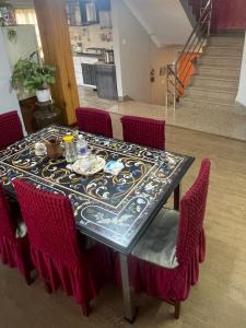 a dining room table with red chairs and a table with at DND House in Pātan