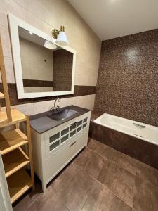 een badkamer met een wastafel, een bad en een spiegel bij Onlyroom Madrid Gabriel Usera in Madrid
