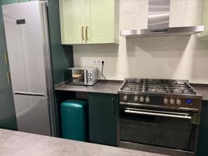 een keuken met een fornuis en een koelkast bij Onlyroom Madrid Gabriel Usera in Madrid