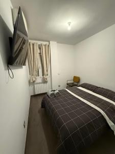 een slaapkamer met twee bedden en een flatscreen-tv bij Onlyroom Madrid Gabriel Usera in Madrid