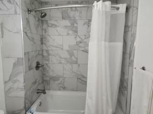 a shower with a white shower curtain in a bathroom at Torraille Waterfall Villas in Soufrière +4 photos