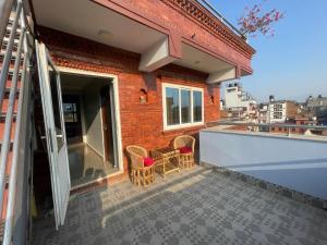 a balcony with wicker chairs on a brick building at DND House in Pātan