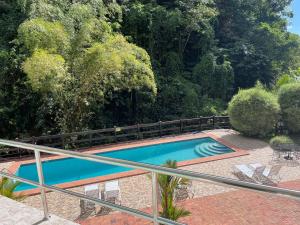 una piscina in un cortile con sedie e alberi di Torraille Waterfall Villas a Soufriere Altre 6 foto