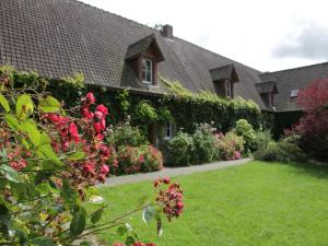 une maison avec une cour verdoyante ornée de fleurs roses dans l'établissement Charming Chalet with Swimming Pool in Quend, à Quend
