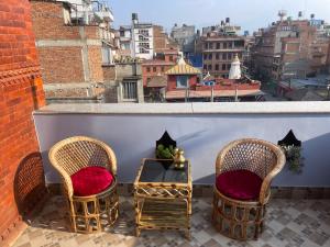 two chairs and a table on a balcony with a view at DND House in Pātan