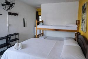 Giường trong phòng chung tại Suíte Tropicália