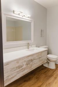 een witte badkamer met een wastafel en een toilet bij King Bed, Jacuzzi, Private Balcony by Gull Lake in Nisswa