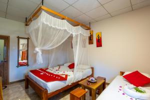 a bedroom with two beds and a mosquito net at Wild Breeze in Tissamaharama