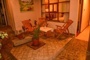 a living room with two chairs and a table with a plant at Hotel Boutique MIRANDO AL SOL in Ollantaytambo
