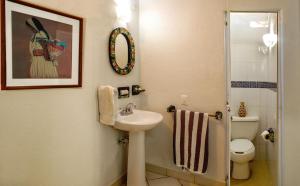 een badkamer met een wastafel, een toilet en een spiegel bij Hotel Zandoyo Bed & Breakfast in Puerto Escondido +45 foto's