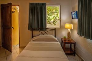een slaapkamer met een bed en een raam bij Hotel Zandoyo Bed & Breakfast in Puerto Escondido