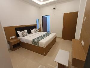 een slaapkamer met een groot bed in een kamer bij HOTEL JMM inn in Debāri